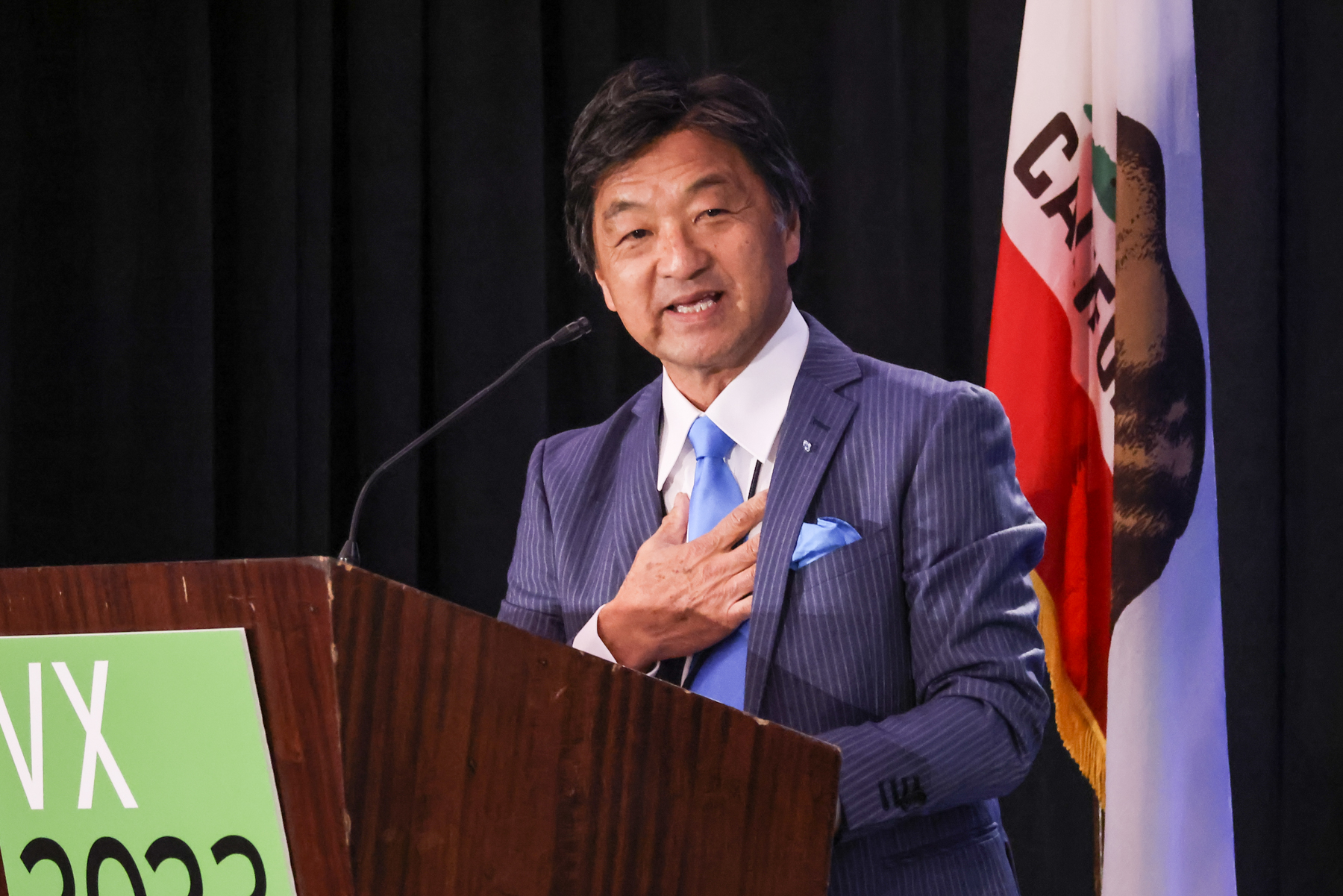 Hiroshi Tomita speaking at the podium