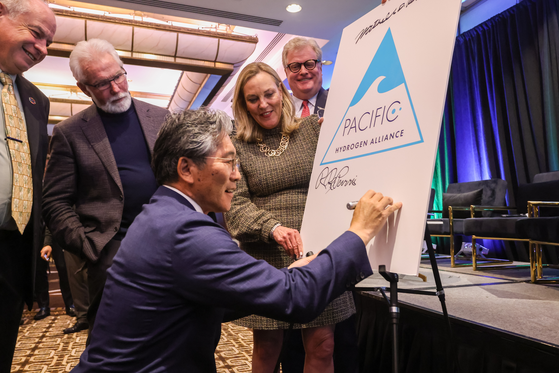 Lancaster Mayor R. Rex Parris,  Hawaii County Mayor Mitch Roth, LA County Supervisor Kathryn Barger, Enso Infrastructure's Lex Heslin watching Mayor of Namie Town Japan Eiko Yoshida sign Pacific Hydrogen Alliance recognition